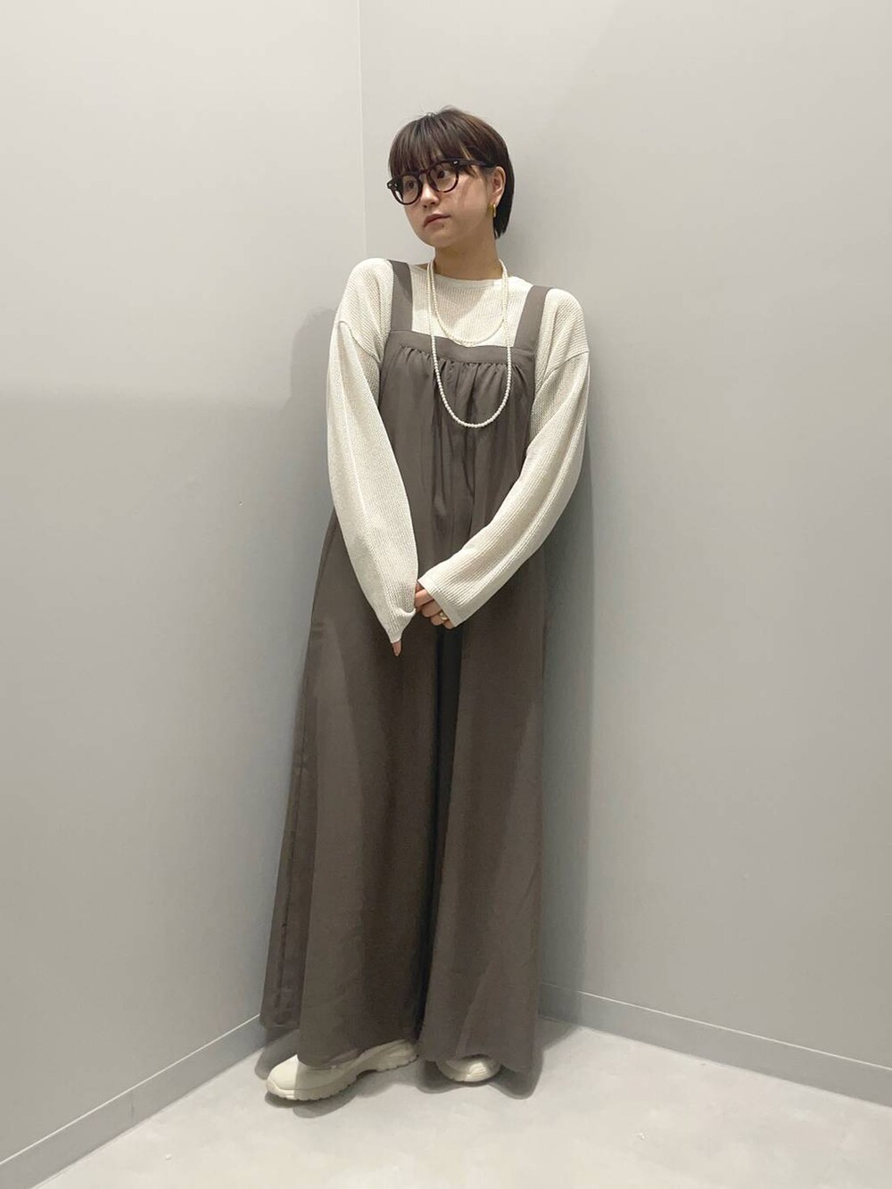 ホワイト系のニット/セーター、ホワイト系のスニーカーを着用したレディースの春コーディネートの2枚目の写真