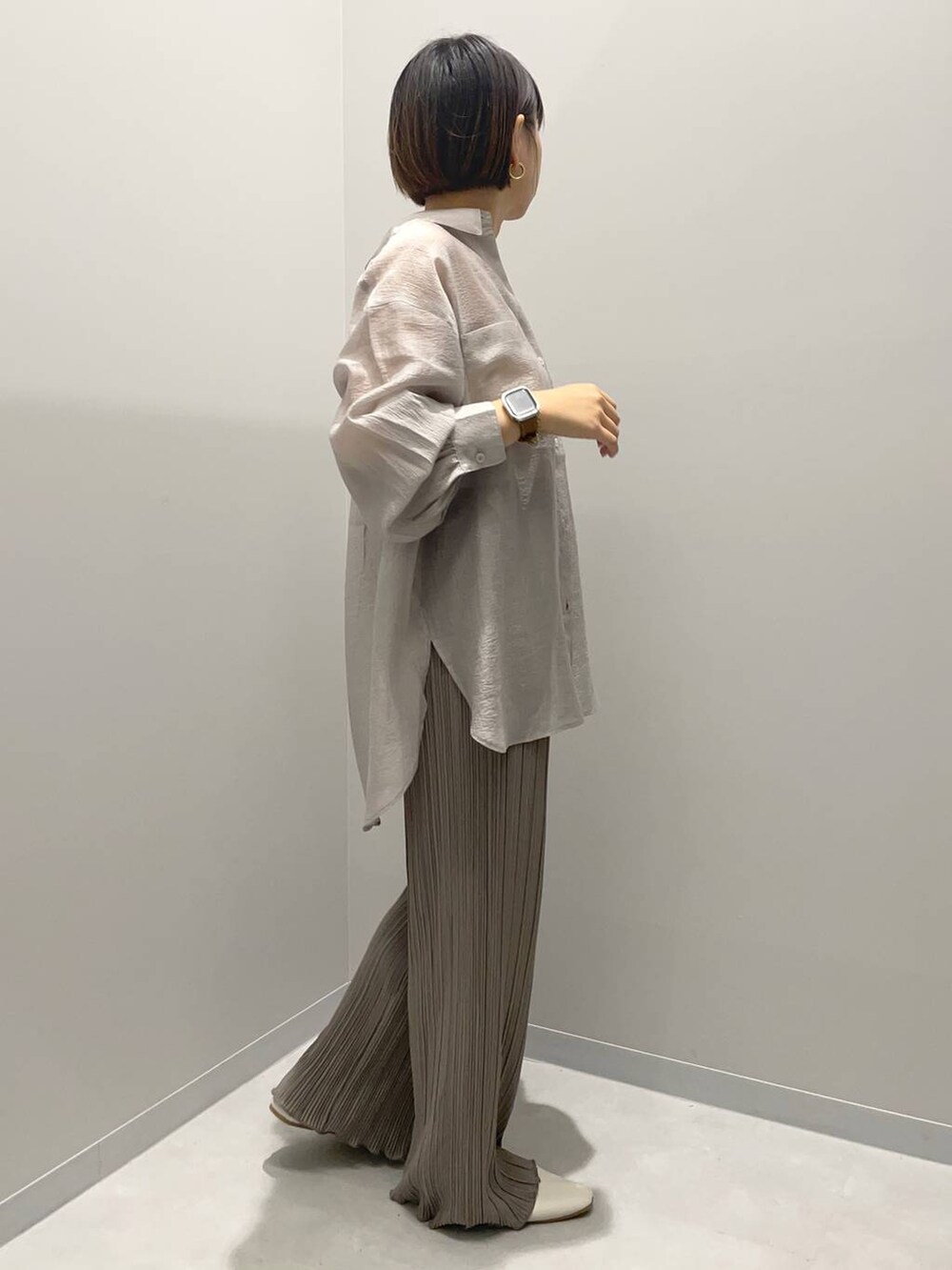 グレー系のシャツ/ブラウス、ブラウン系のその他パンツ、イエロー系のネックレスを着用したレディースの秋コーディネートの2枚目の写真