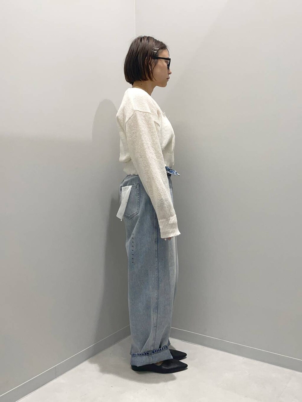 ブルー系のデニムパンツ、ホワイト系のカーディガン/ボレロを着用したレディースの春コーディネートの3枚目の写真