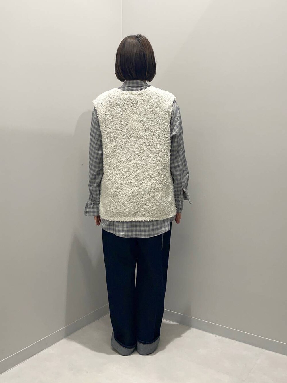 ブルー系のデニムパンツ、グリーン系のシャツ/ブラウス、ホワイト系のベストを着用したレディースの春コーディネートの5枚目の写真