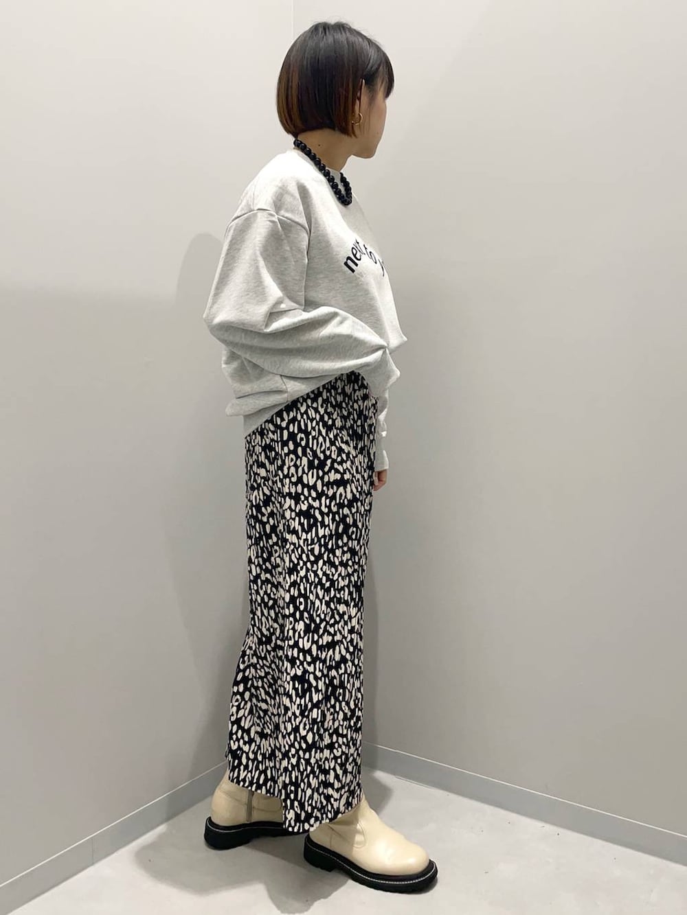 グレー系のTシャツ/カットソー、グレー系のスカートを着用したレディースの秋コーディネートの2枚目の写真