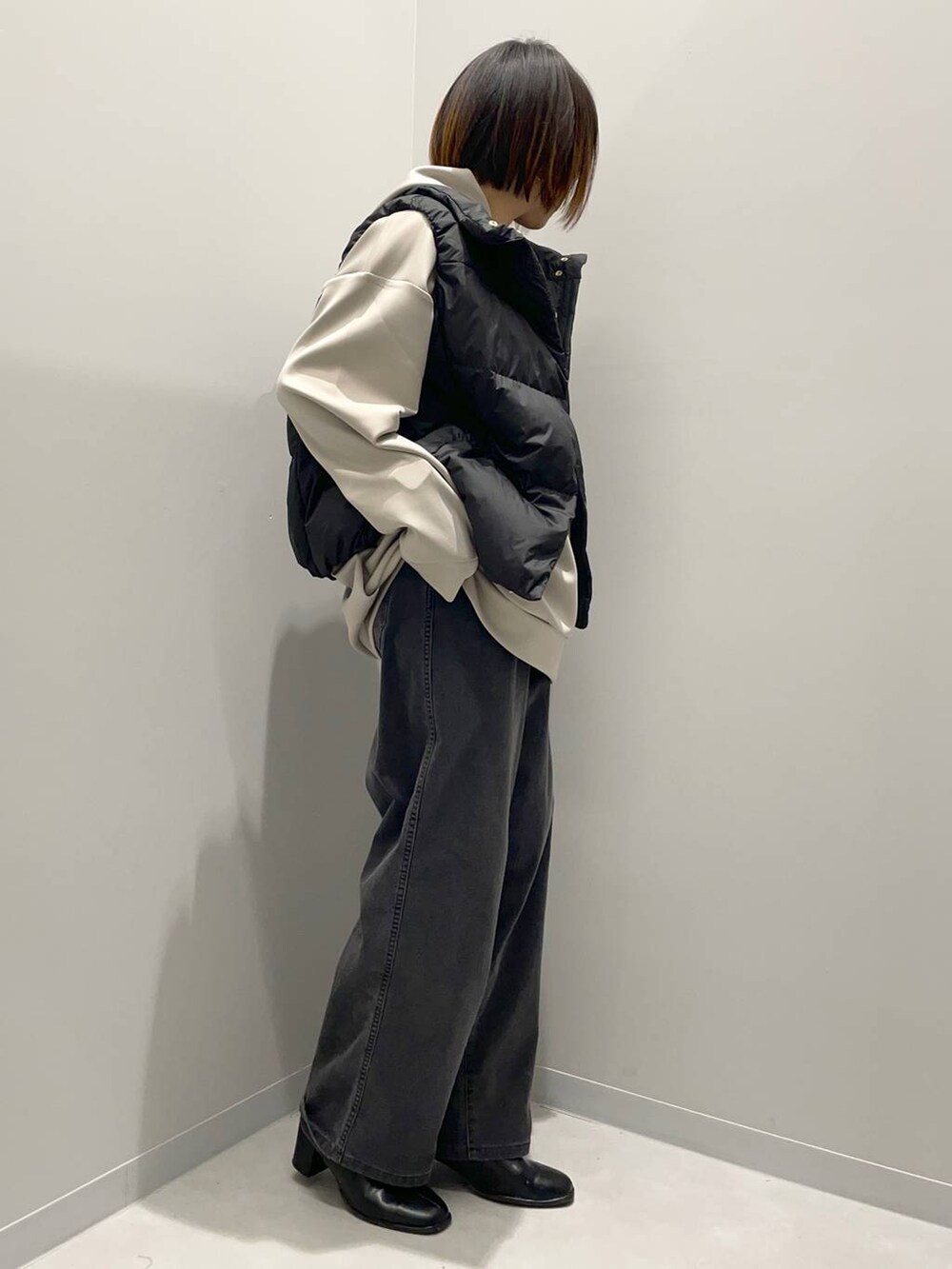 ブラック系のデニムパンツ、ベージュ系のパーカー、ブラック系のその他アウターを着用したレディースの秋コーディネートの3枚目の写真