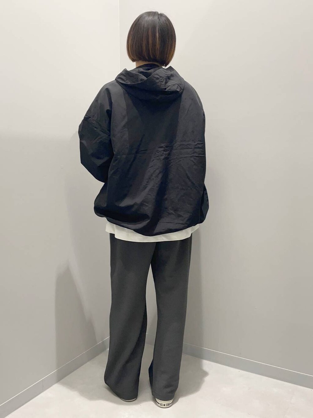 ホワイト系のTシャツ/カットソー、ブラック系のブルゾン、グレー系のその他パンツを着用したレディースの秋コーディネートの3枚目の写真