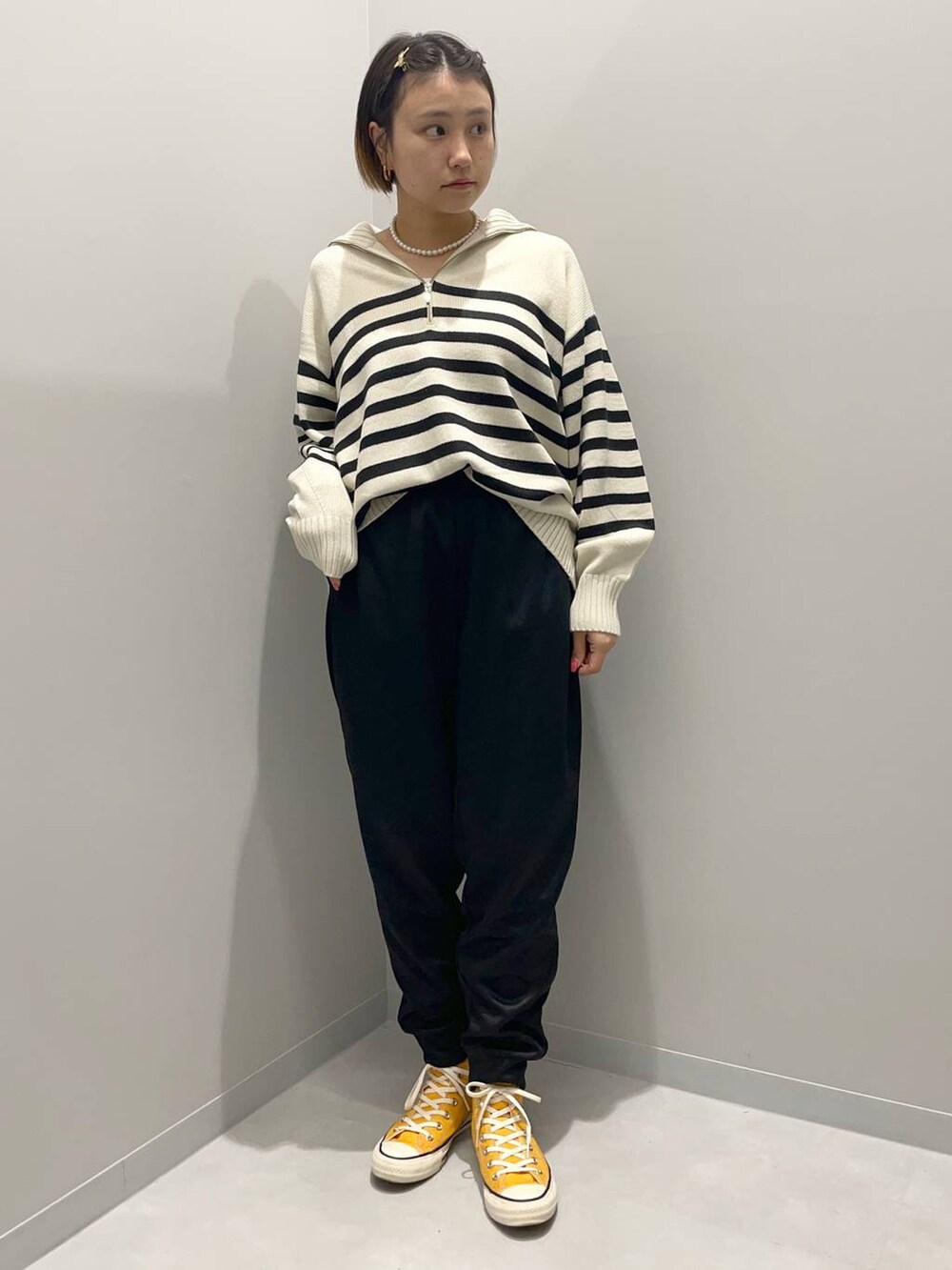 グレー系のニット/セーター、ブラック系のスウェットパンツを着用したレディースの秋コーディネートの2枚目の写真