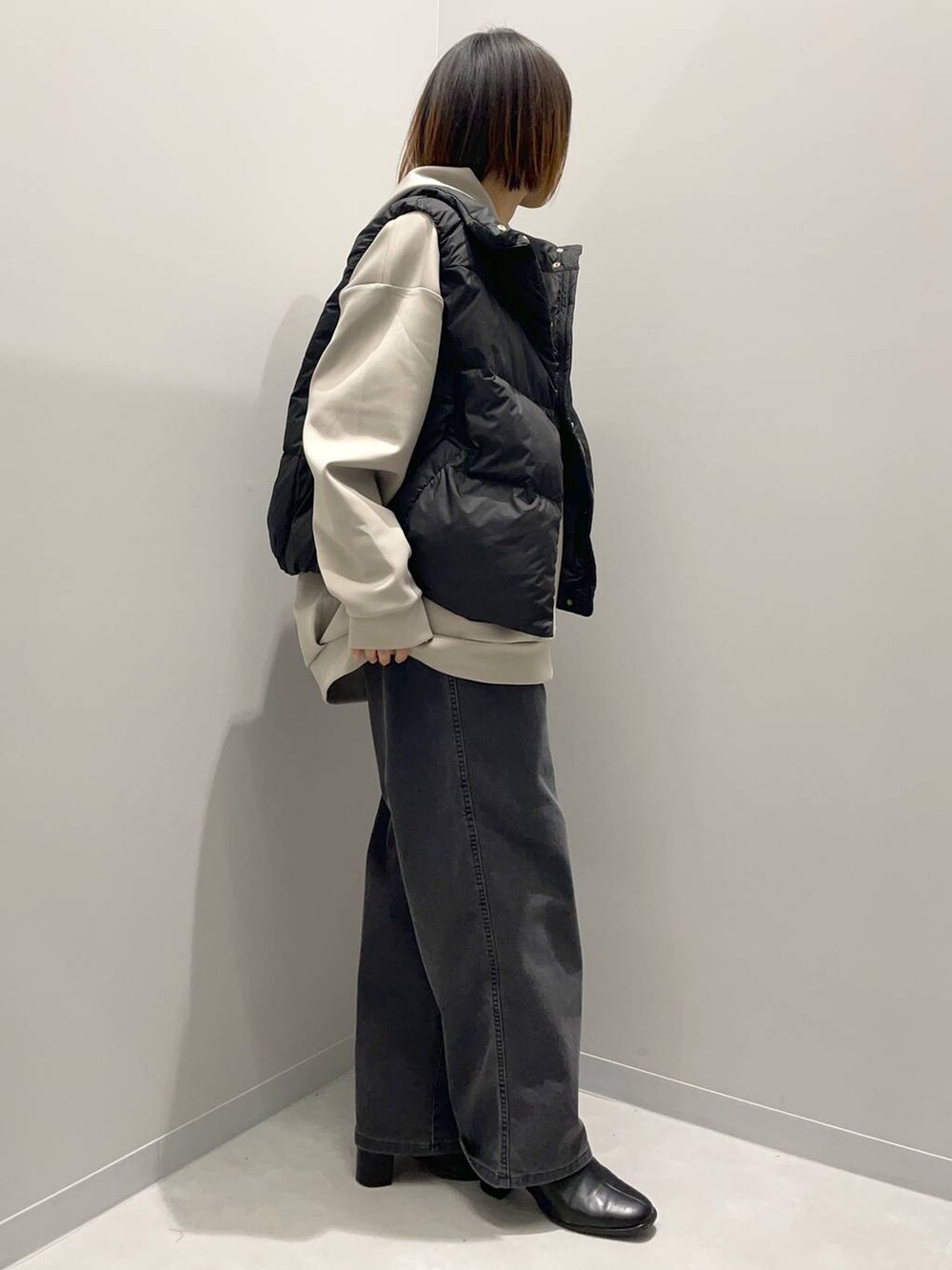 ブラック系のデニムパンツ、ベージュ系のパーカー、ブラック系のその他アウターを着用したレディースの秋コーディネートの4枚目の写真