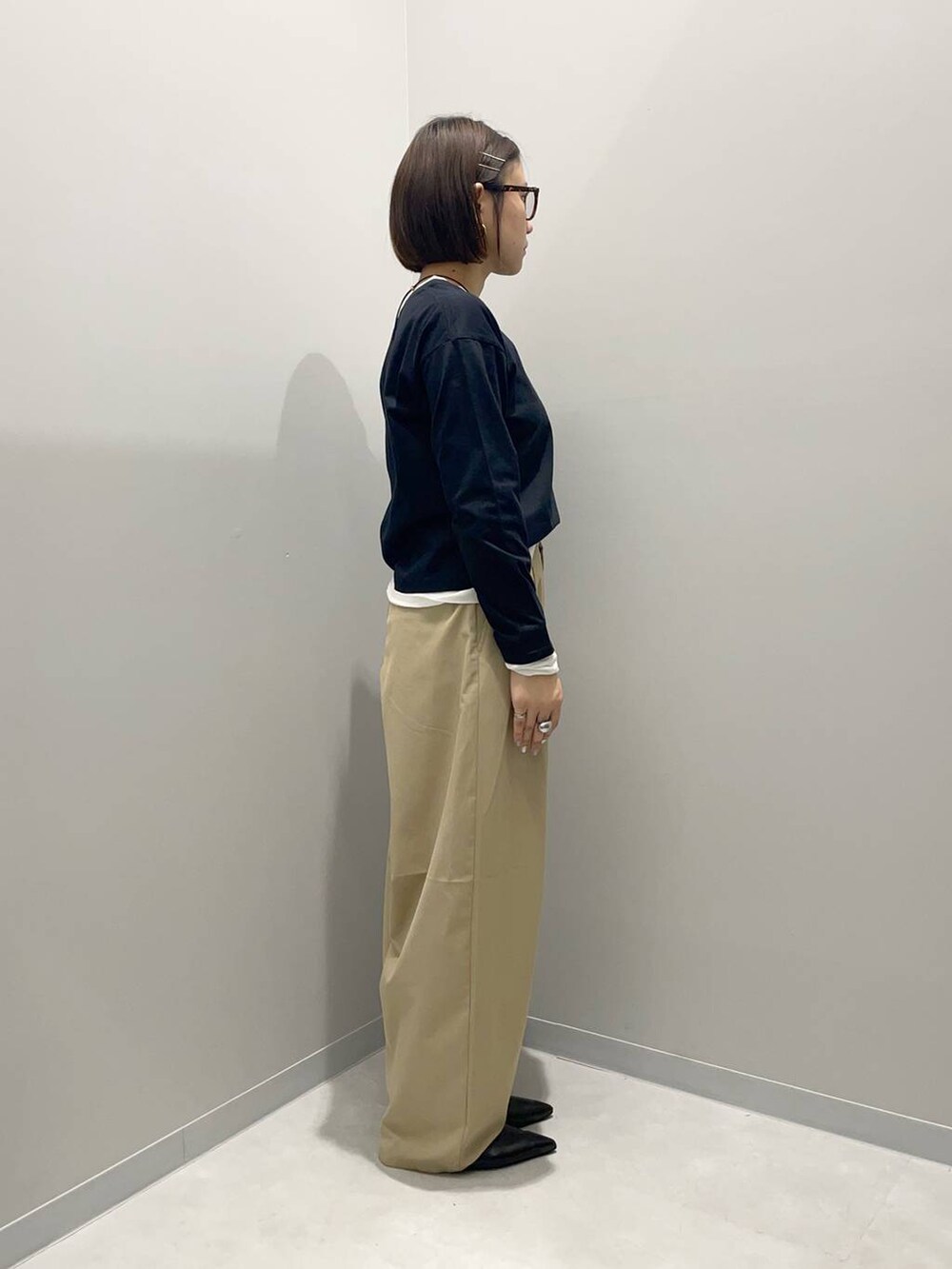 ベージュ系のその他パンツ、ブラック系のTシャツ/カットソー、イエロー系のネックレスを着用したレディースの春コーディネートの3枚目の写真