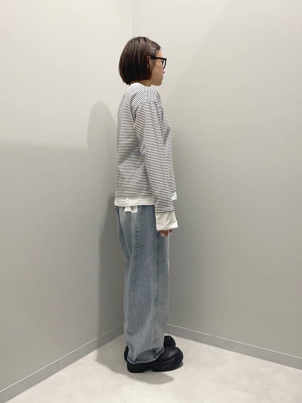 ブルー系のデニムパンツ、ブラウン系のショルダーバッグ、その他のTシャツ/カットソーを着用したレディースの春コーディネートの3枚目の写真