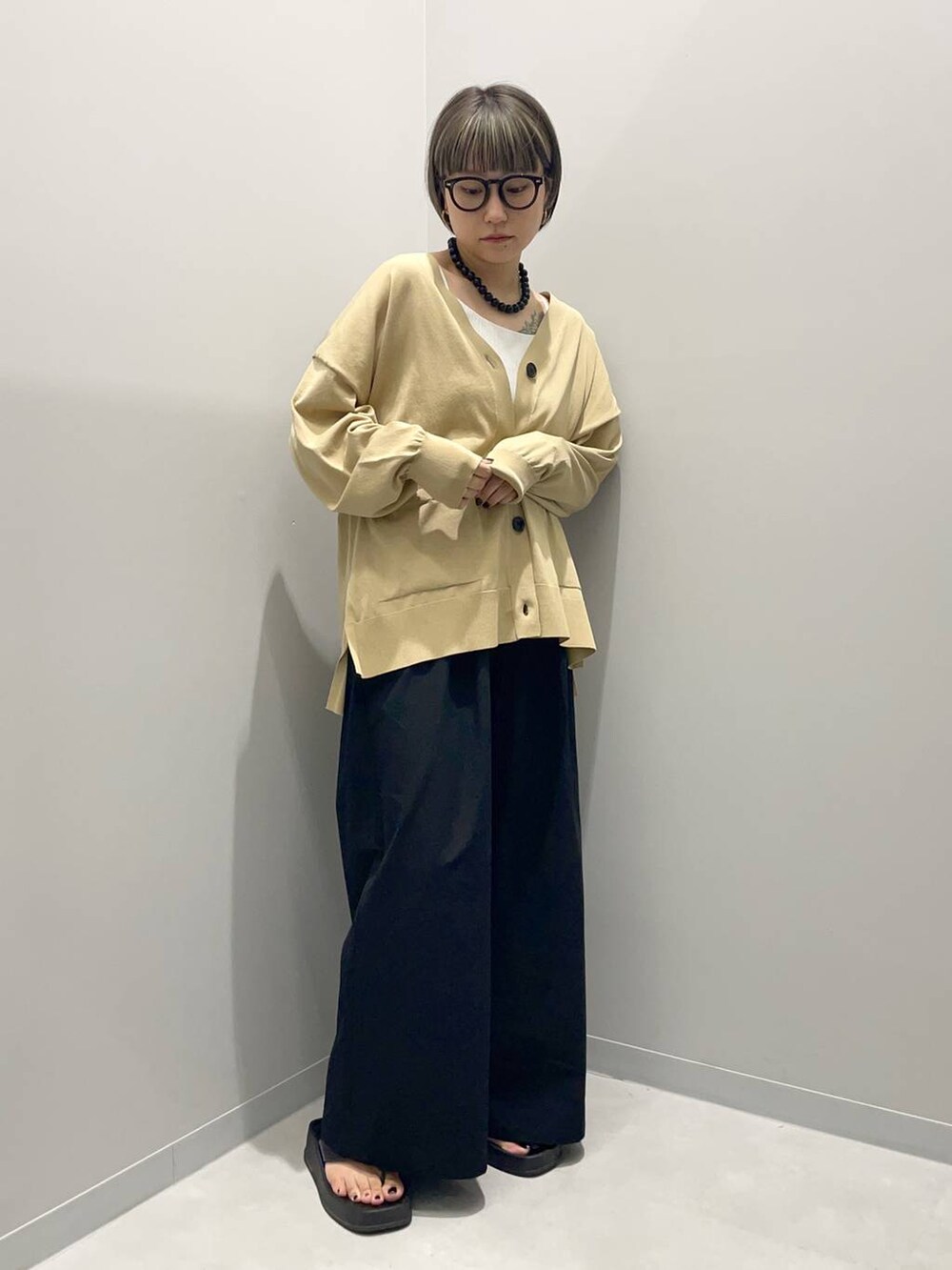 ベージュ系のカーディガン/ボレロ、ブラック系のその他パンツを着用したレディースの夏コーディネートの2枚目の写真