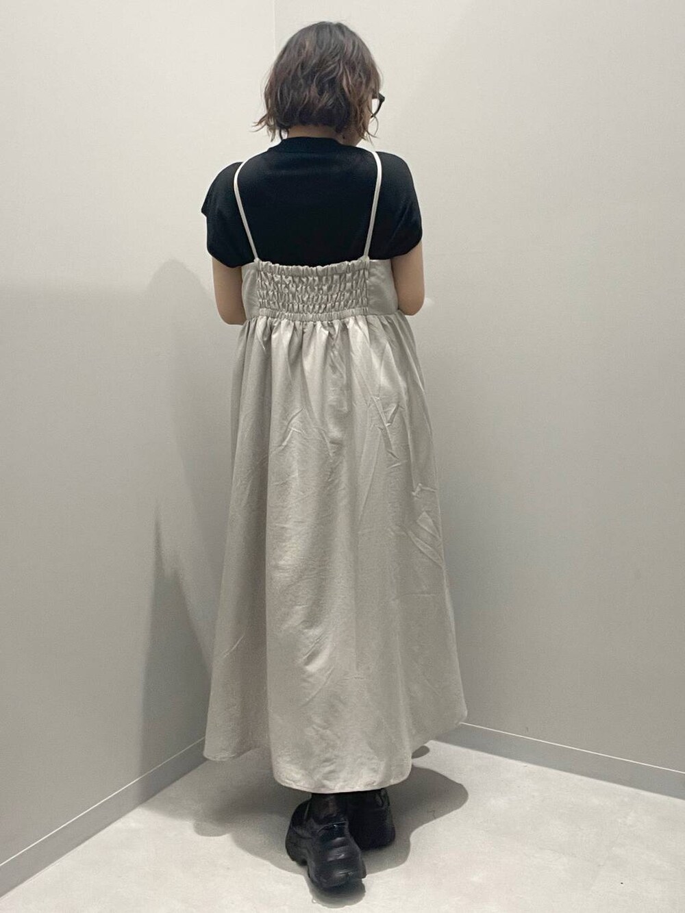 グレー系のワンピース、ブラック系のニット/セーター、ブラック系のソックス/靴下を着用したレディースの春コーディネートの3枚目の写真