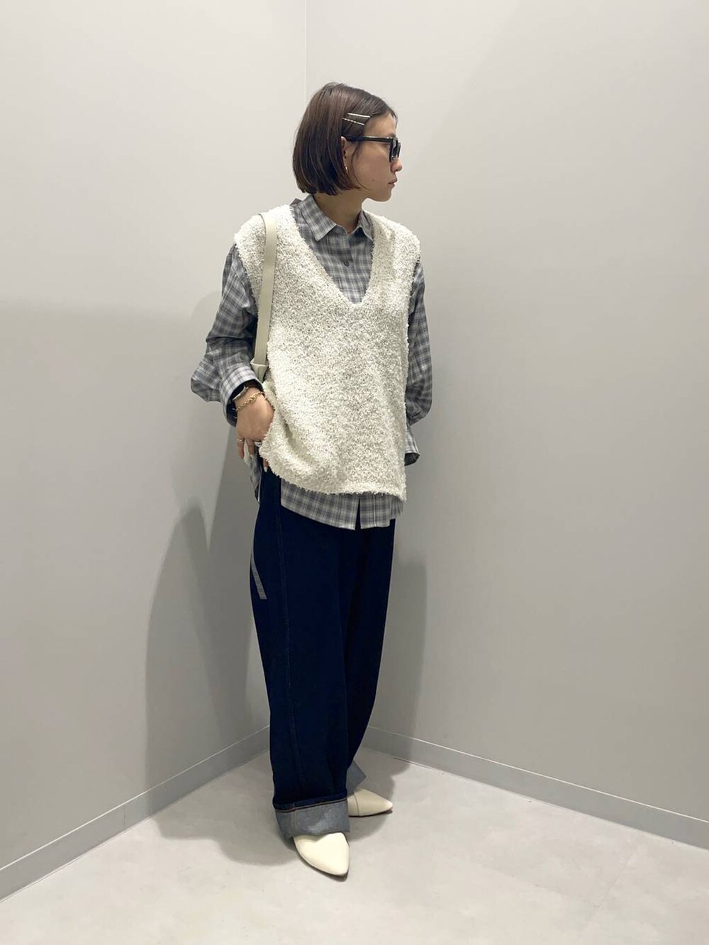 ブルー系のデニムパンツ、グリーン系のシャツ/ブラウス、ホワイト系のベストを着用したレディースの春コーディネートの3枚目の写真