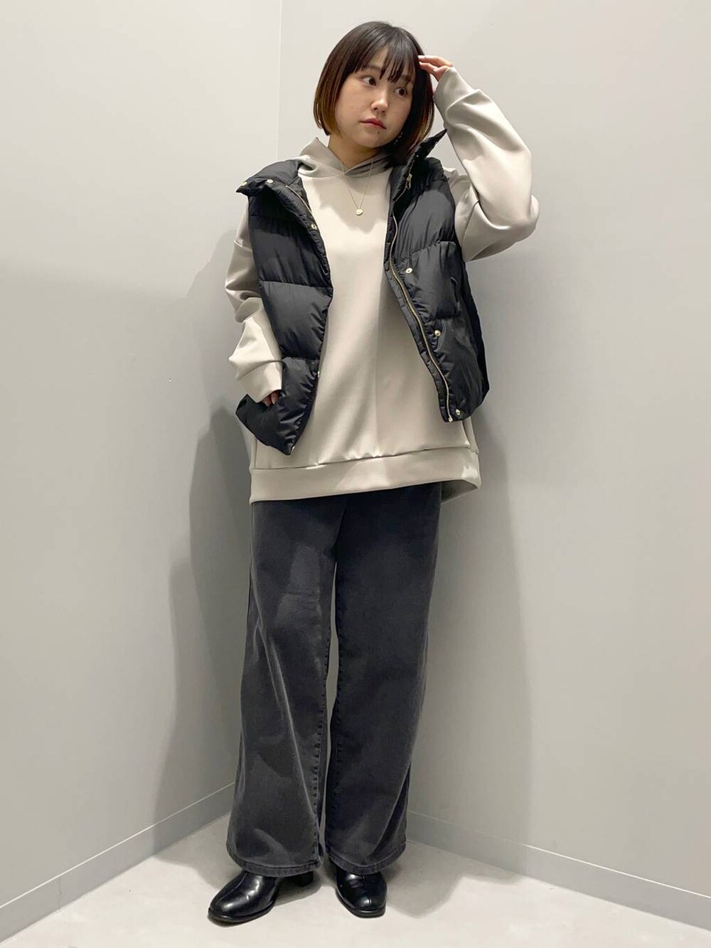 ブラック系のデニムパンツ、ベージュ系のパーカー、ブラック系のその他アウターを着用したレディースの秋コーディネートの2枚目の写真