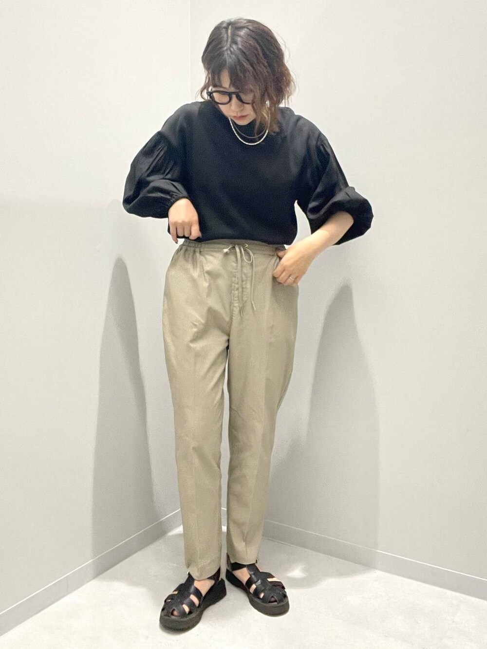 ベージュ系のその他パンツ、ブラック系のシャツ/ブラウス、ホワイト系のネックレスを着用したレディースの春コーディネートの2枚目の写真