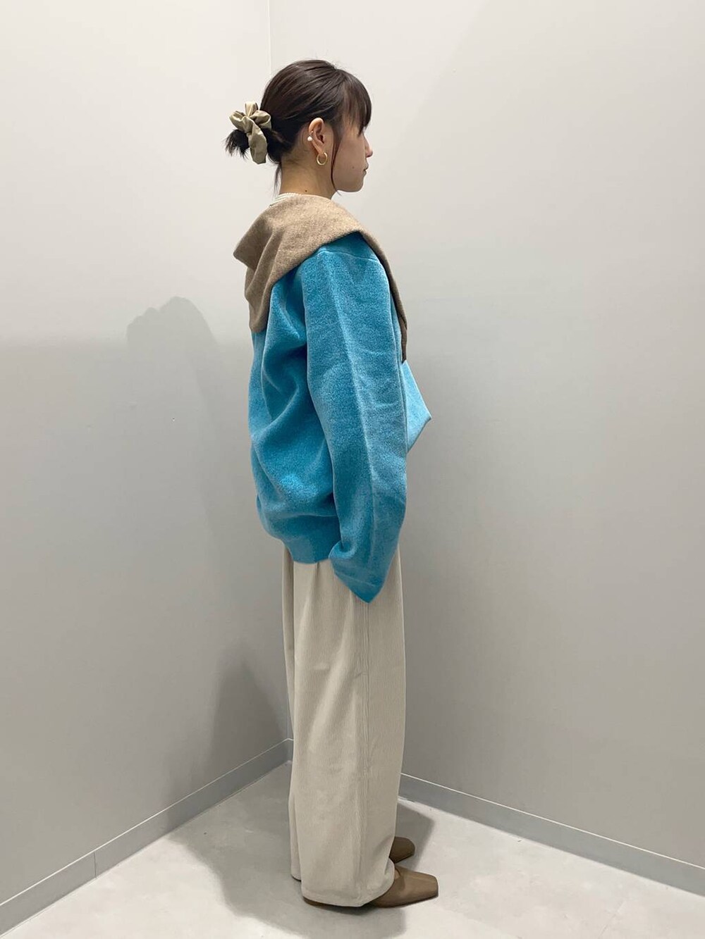 グレー系のその他パンツ、ブルー系のニット/セーター、ブラウン系のハンドバッグを着用したレディースの秋コーディネートの3枚目の写真