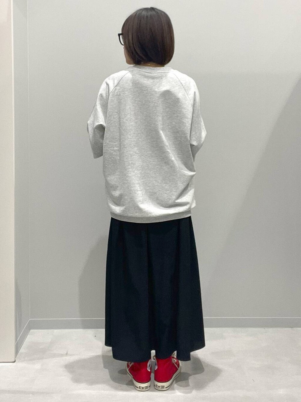 グレー系のTシャツ/カットソー、ブラック系のスカート、グレー系のネックレスを着用したレディースの春コーディネートの2枚目の写真