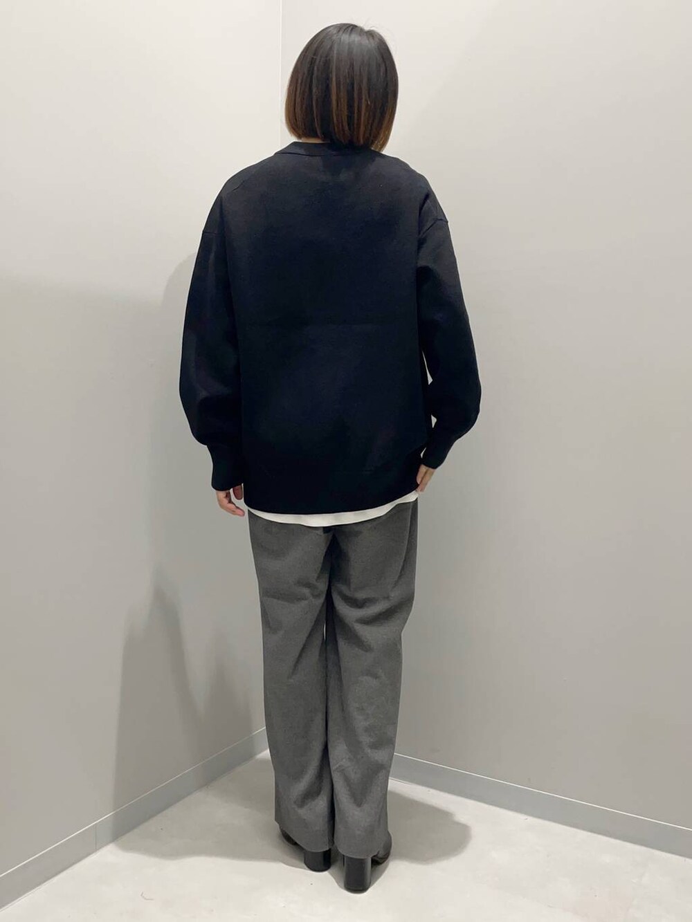 グレー系のその他パンツ、ホワイト系のTシャツ/カットソー、ブラック系のニット/セーターを着用したレディースの秋コーディネートの3枚目の写真