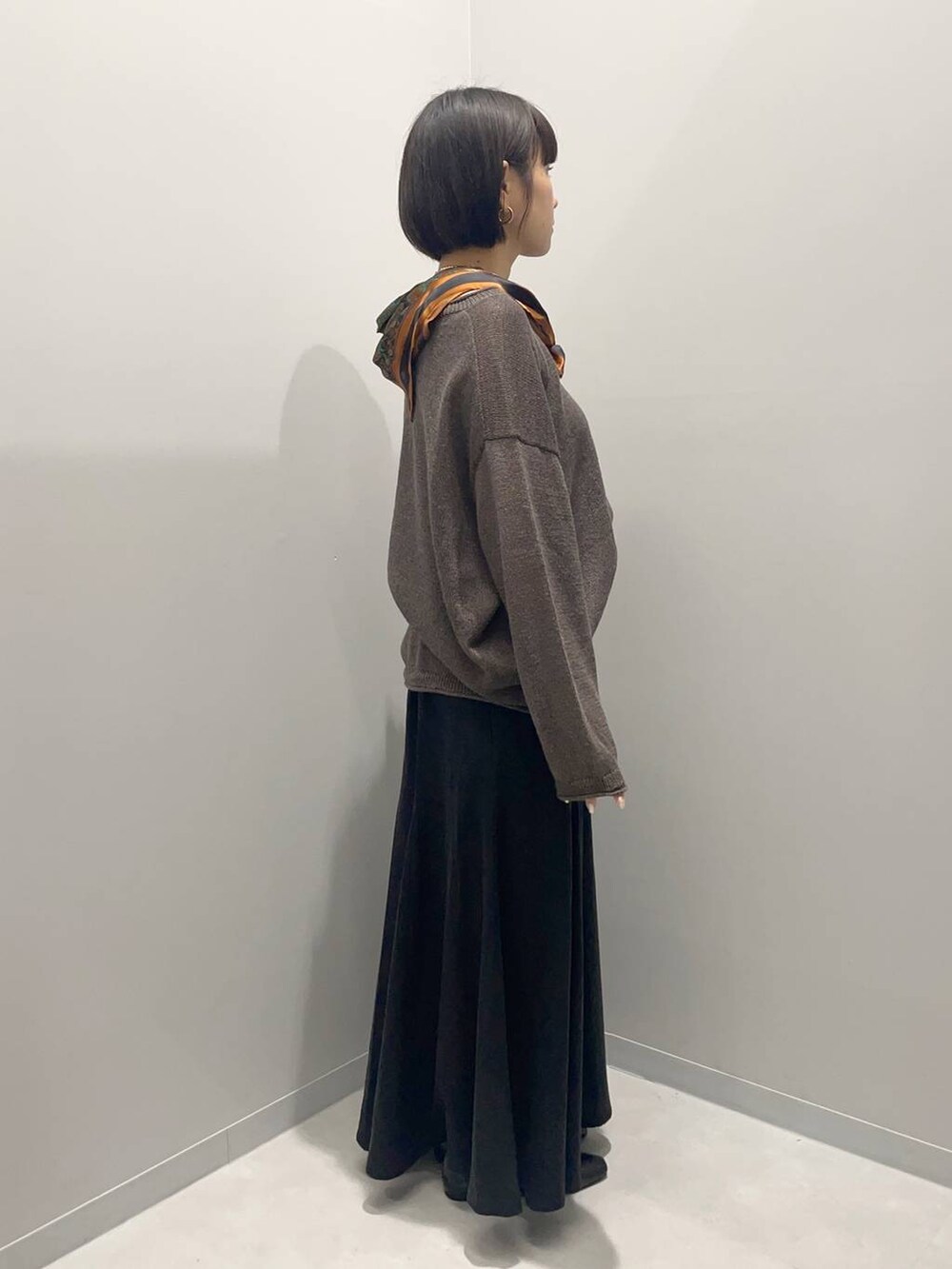 ブラウン系のニット/セーターを着用したレディースの秋コーディネートの2枚目の写真