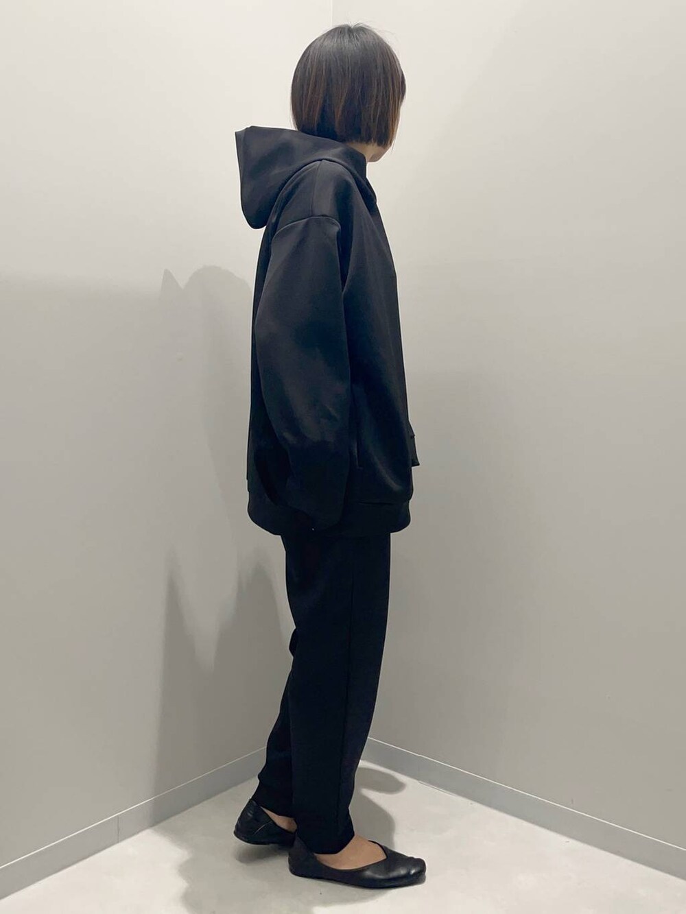 ブラック系のパーカー、ブラック系のスウェットパンツを着用したレディースの秋コーディネートの3枚目の写真