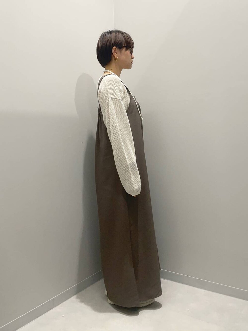 ホワイト系のニット/セーター、ホワイト系のスニーカーを着用したレディースの春コーディネートの4枚目の写真