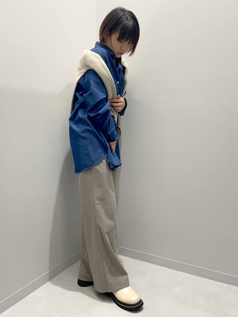 ブラウン系のその他パンツ、ブルー系のシャツ/ブラウス、ベージュ系のニット/セーターを着用したレディースの秋コーディネートの3枚目の写真