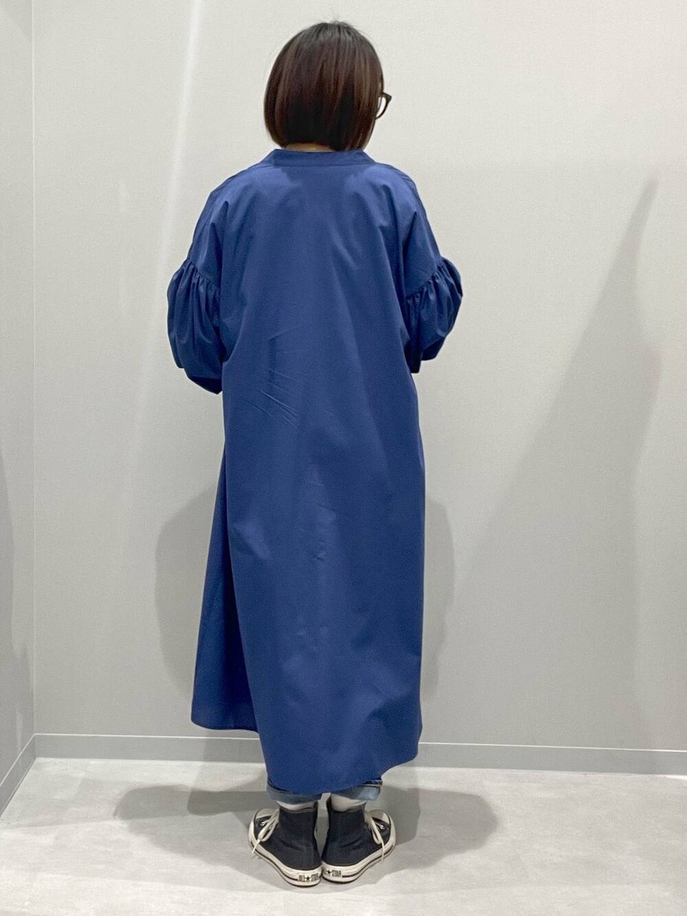 ホワイト系のTシャツ/カットソー、ブルー系のシャツワンピース、ブルー系のデニムパンツを着用したレディースの春コーディネートの3枚目の写真