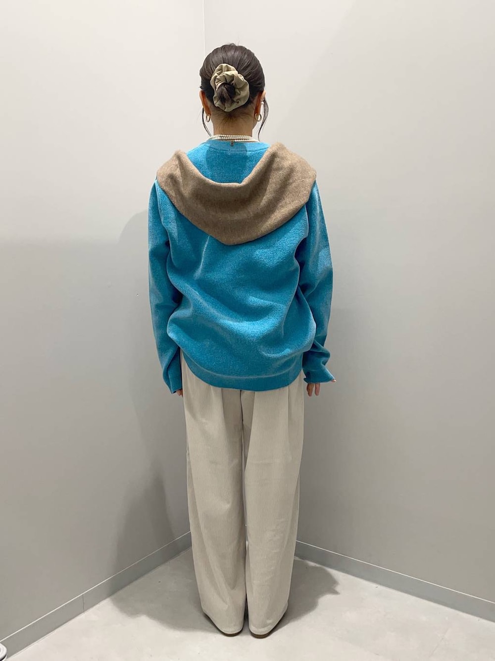 グレー系のその他パンツ、ブルー系のニット/セーター、ブラウン系のハンドバッグを着用したレディースの秋コーディネートの4枚目の写真