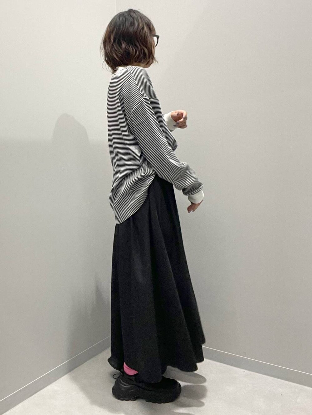 ブラック系のスカート、グレー系のTシャツ/カットソーを着用したレディースの春コーディネートの2枚目の写真