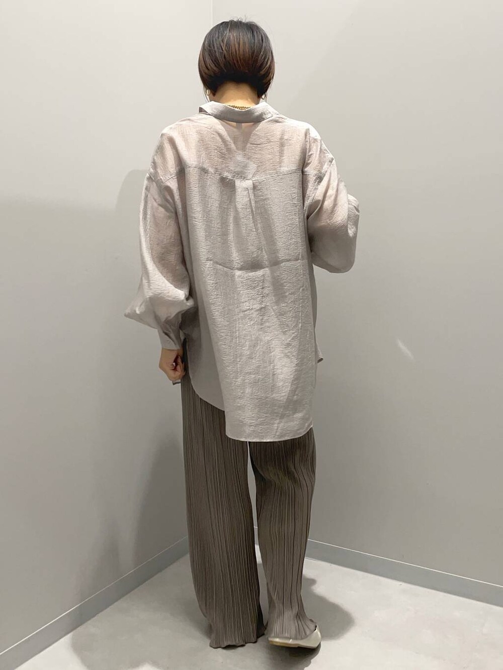 グレー系のシャツ/ブラウス、ブラウン系のその他パンツ、イエロー系のネックレスを着用したレディースの秋コーディネートの3枚目の写真