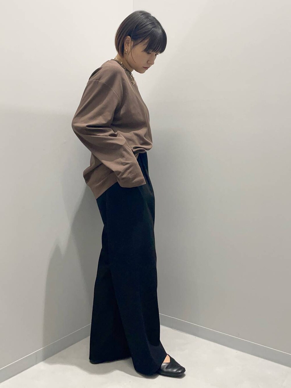 ブラック系のその他パンツ、ブラウン系のTシャツ/カットソー、ゴールド系のネックレスを着用したレディースの秋コーディネートの2枚目の写真