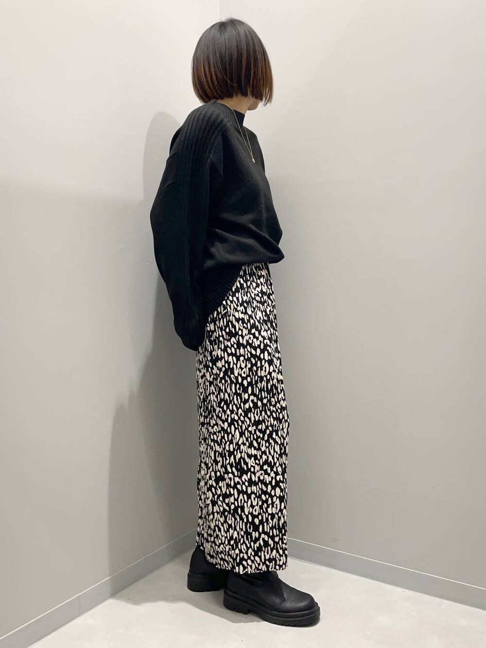 ブラック系のニット/セーター、グレー系のスカートを着用したレディースの秋コーディネートの3枚目の写真