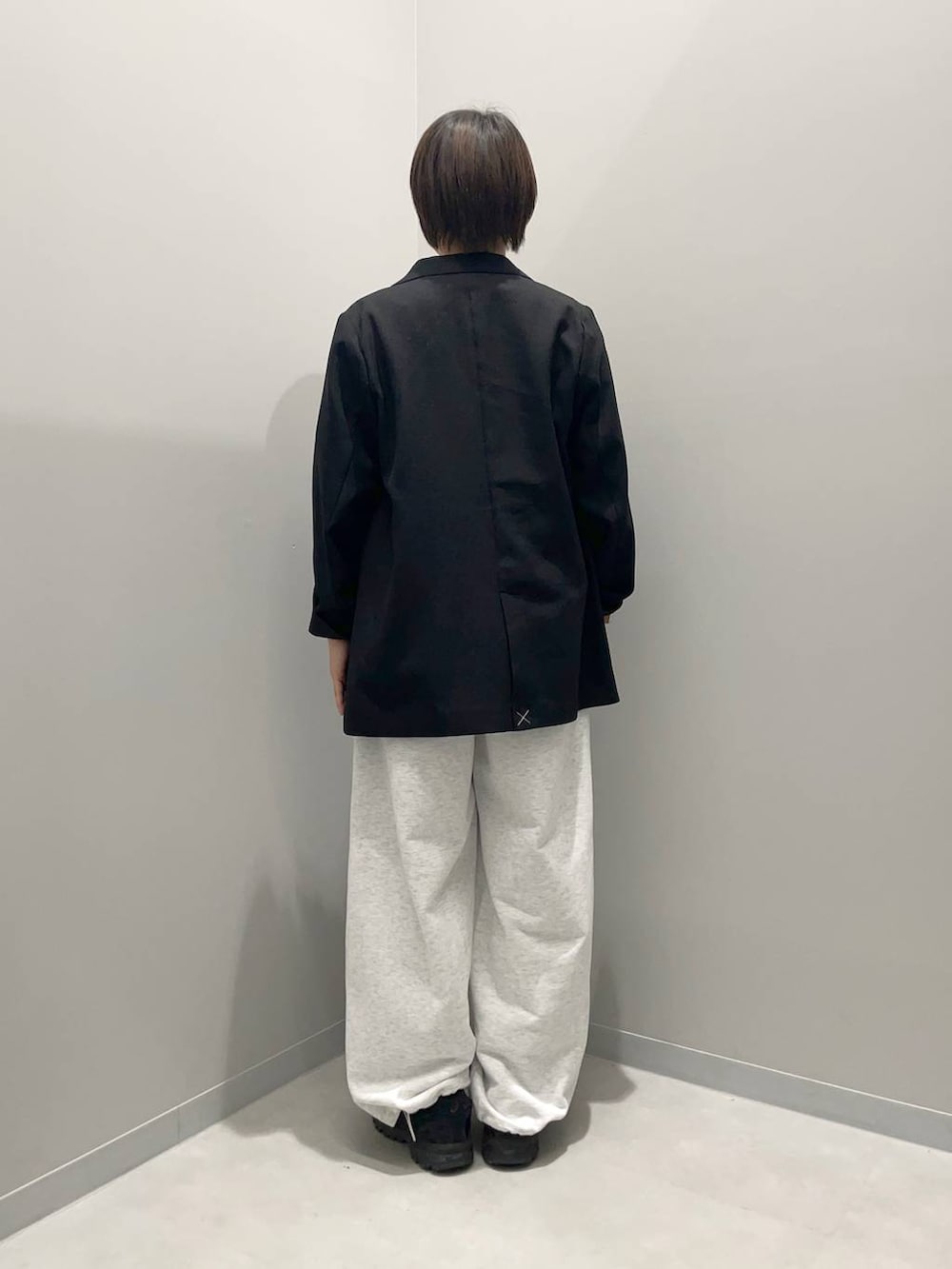 ブラック系のテーラードジャケット、グレー系のスウェットパンツ、レッド系のTシャツ/カットソーを着用したレディースの春コーディネートの5枚目の写真