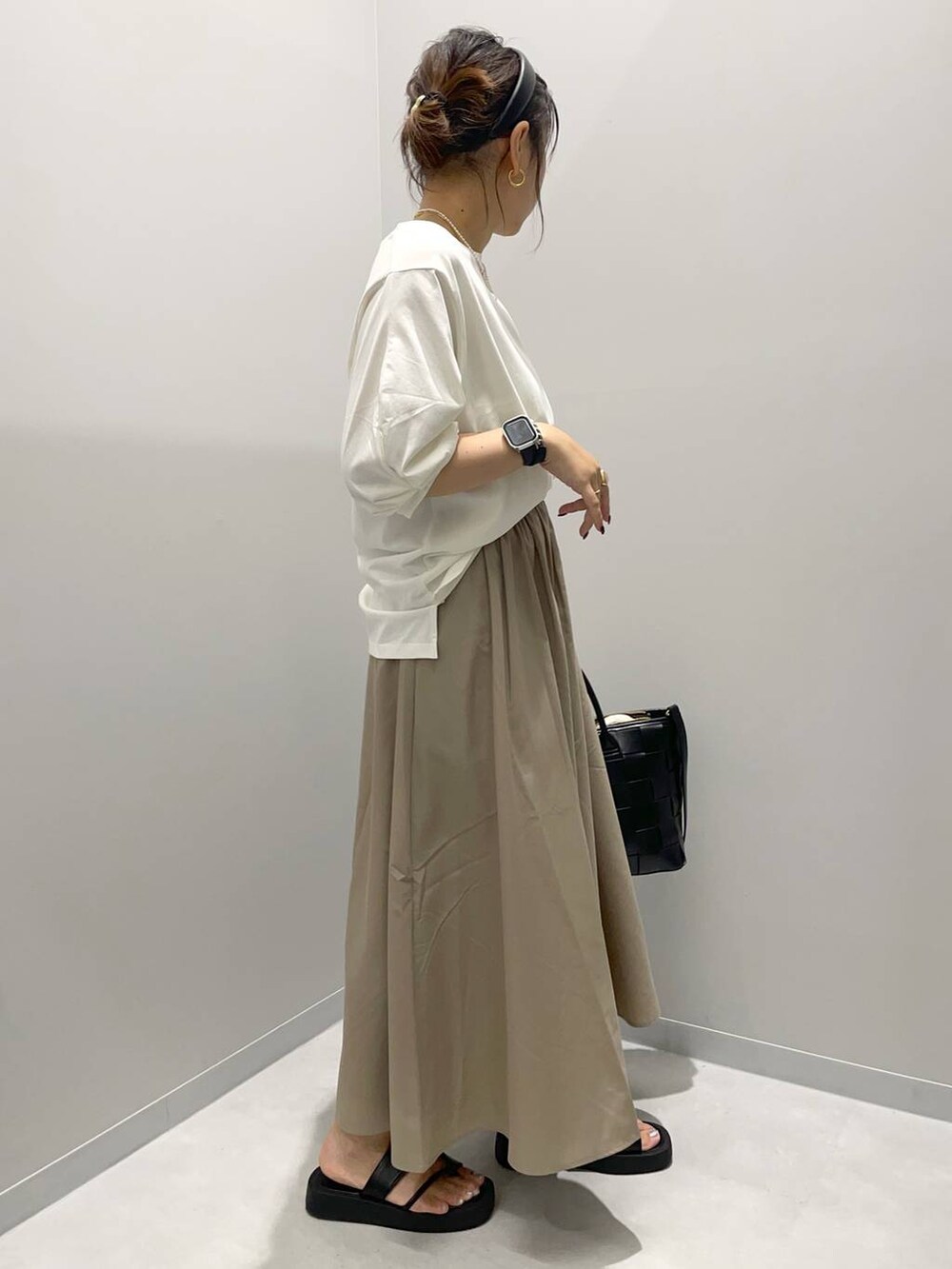 ベージュ系のスカート、ホワイト系のTシャツ/カットソーを着用したレディースの夏コーディネートの2枚目の写真