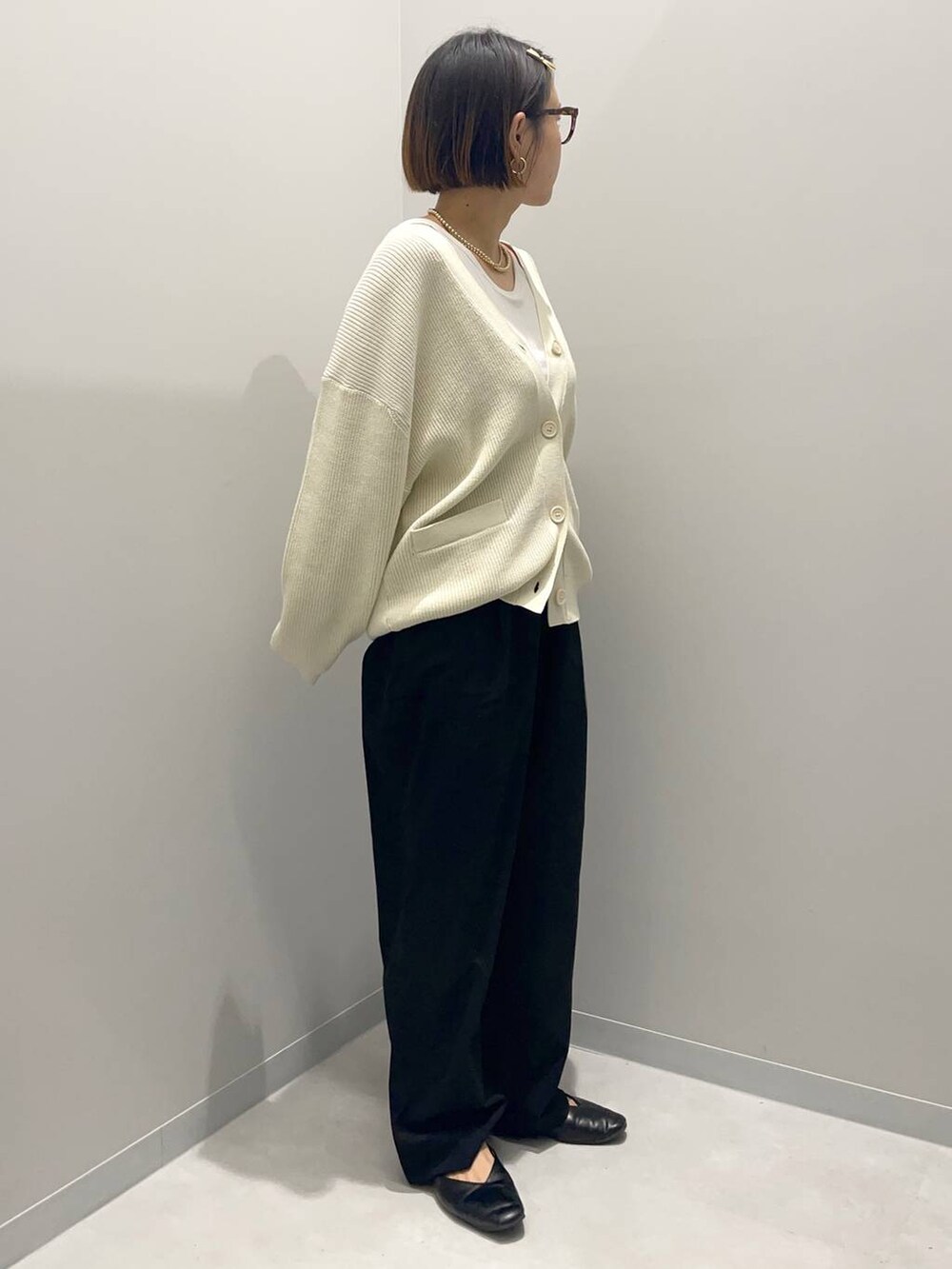 ブラック系のその他パンツ、ホワイト系のニット/セーター、イエロー系のバレッタ/ヘアクリップを着用したレディースの秋コーディネートの3枚目の写真