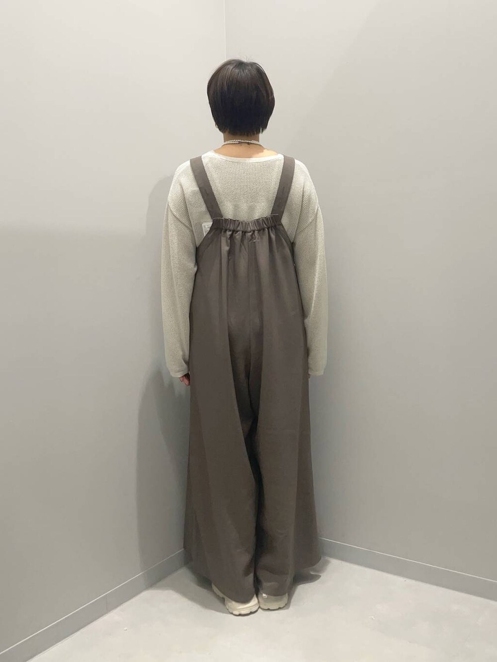 ホワイト系のニット/セーター、ホワイト系のスニーカーを着用したレディースの春コーディネートの5枚目の写真