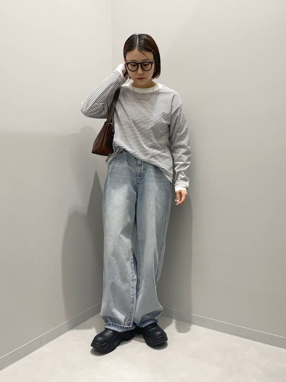 ブルー系のデニムパンツ、ブラウン系のショルダーバッグ、その他のTシャツ/カットソーを着用したレディースの春コーディネートの2枚目の写真