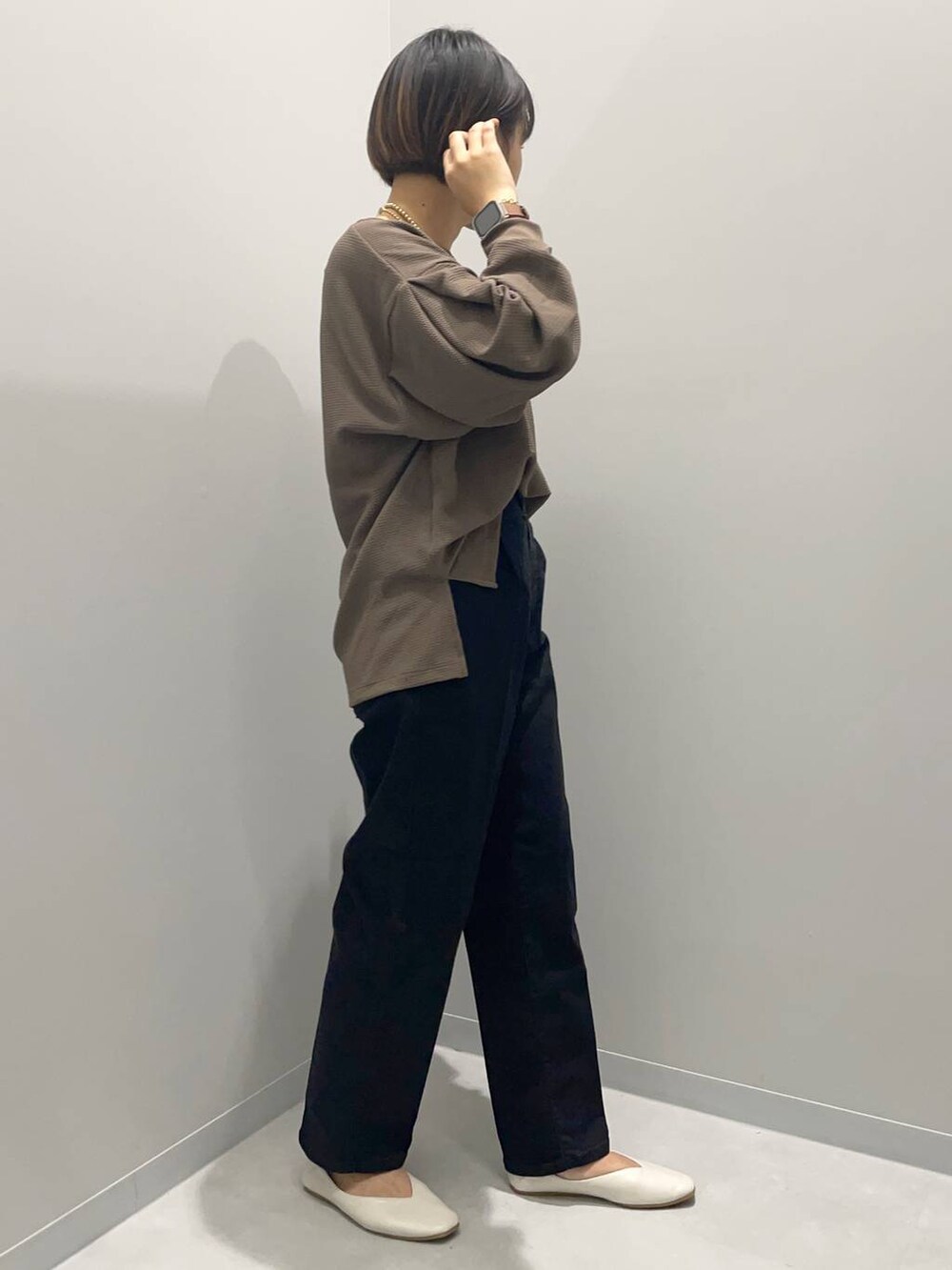 ブラック系のデニムパンツ、ブラウン系のTシャツ/カットソーを着用したレディースの秋コーディネートの2枚目の写真