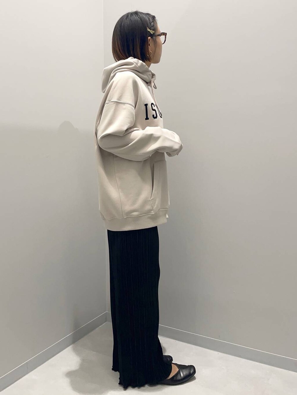 ベージュ系のパーカー、ブラック系のその他パンツを着用したレディースの秋コーディネートの2枚目の写真