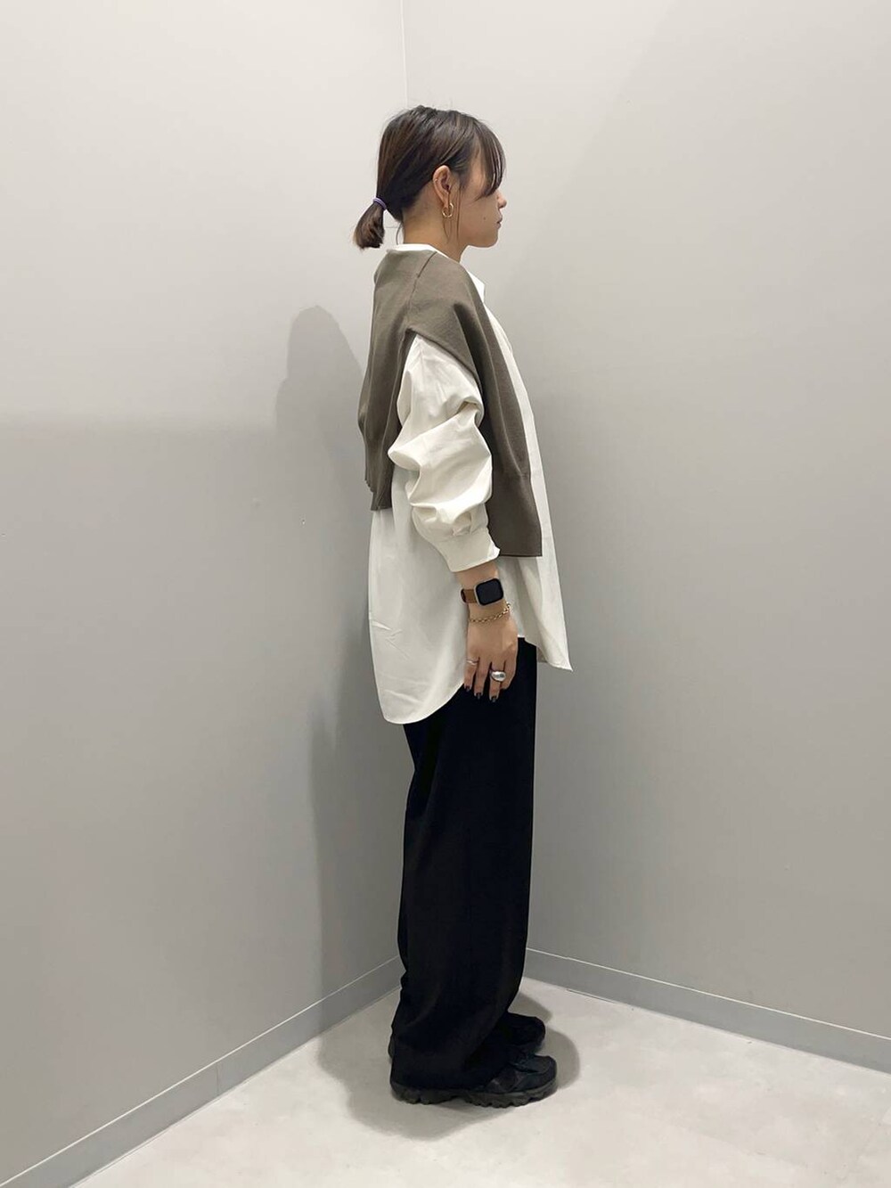 ブラック系のその他パンツ、ブラウン系のニット/セーター、ホワイト系のシャツ/ブラウスを着用したレディースの春コーディネートの4枚目の写真