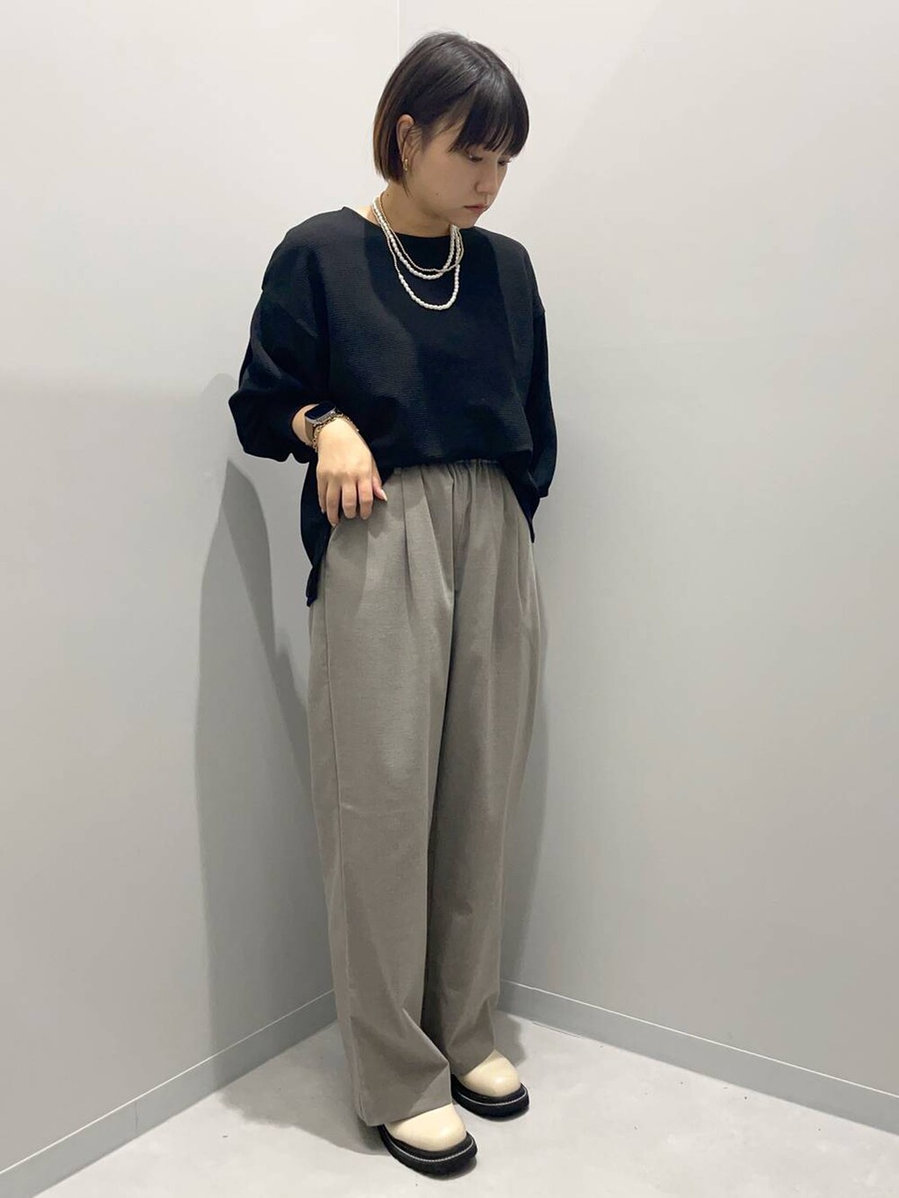 ブラウン系のその他パンツ、ブラック系のTシャツ/カットソー、ゴールド系のネックレスを着用したレディースの秋コーディネートの2枚目の写真