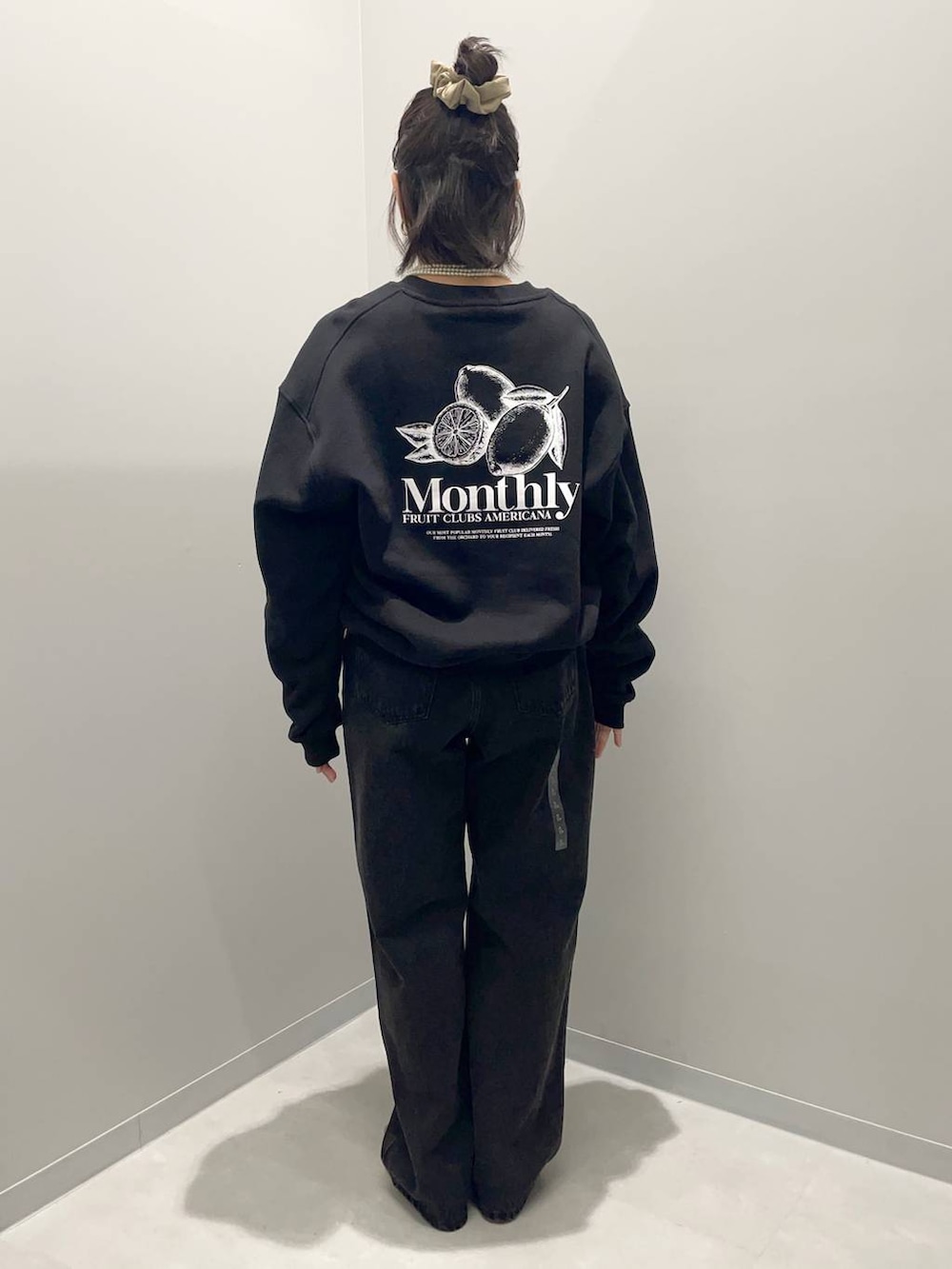 ブラック系のデニムパンツ、ブラウン系のハンドバッグ、ブラック系のスウェットを着用したレディースの秋コーディネートの4枚目の写真