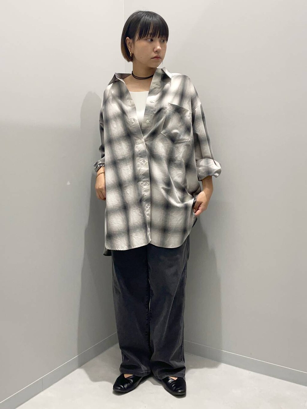 ブラック系のデニムパンツ、グレー系のシャツ/ブラウスを着用したレディースの秋コーディネートの2枚目の写真