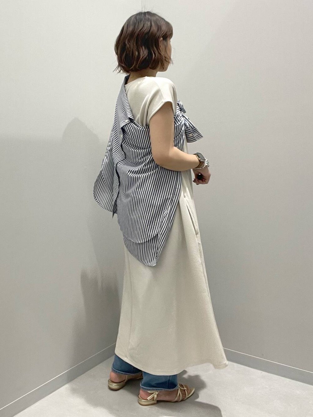 ホワイト系のワンピース、ブルー系のシャツ/ブラウス、ブルー系のデニムパンツを着用したレディースの春コーディネートの2枚目の写真