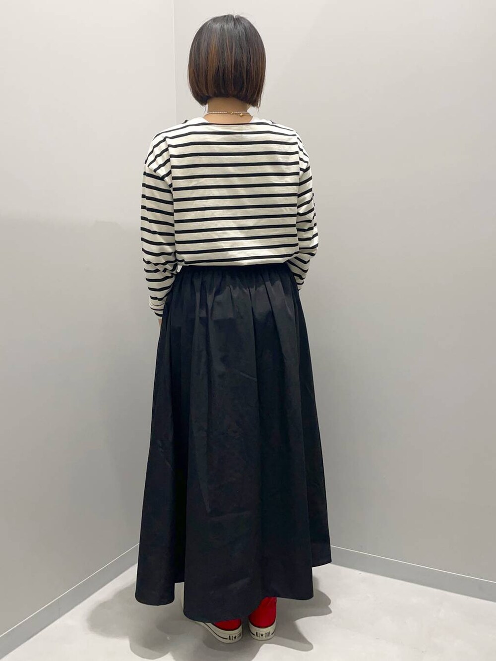 ブラック系のスカート、グレー系のTシャツ/カットソーを着用したレディースの夏コーディネートの4枚目の写真