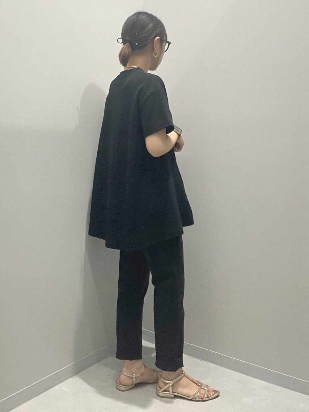 ブラック系のTシャツ/カットソー、ブラック系のデニムパンツ、イエロー系のネックレスを着用したレディースの夏コーディネートの3枚目の写真