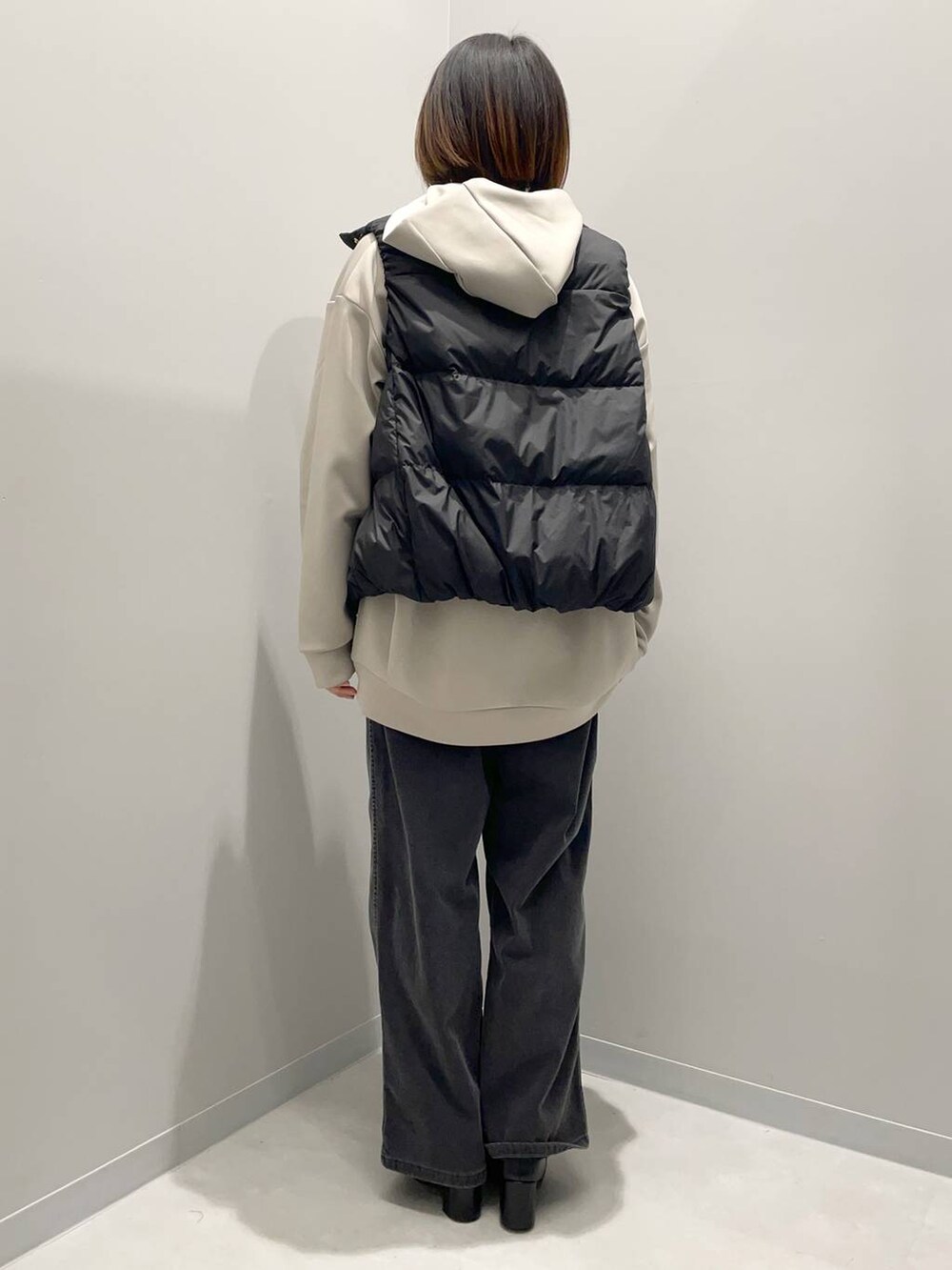 ブラック系のデニムパンツ、ベージュ系のパーカー、ブラック系のその他アウターを着用したレディースの秋コーディネートの5枚目の写真