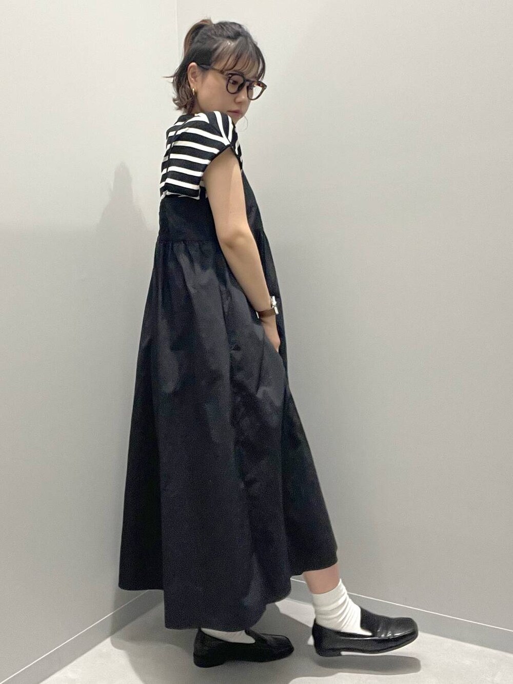 ブラック系のワンピース、グレー系のニット/セーターを着用したレディースの春コーディネートの2枚目の写真