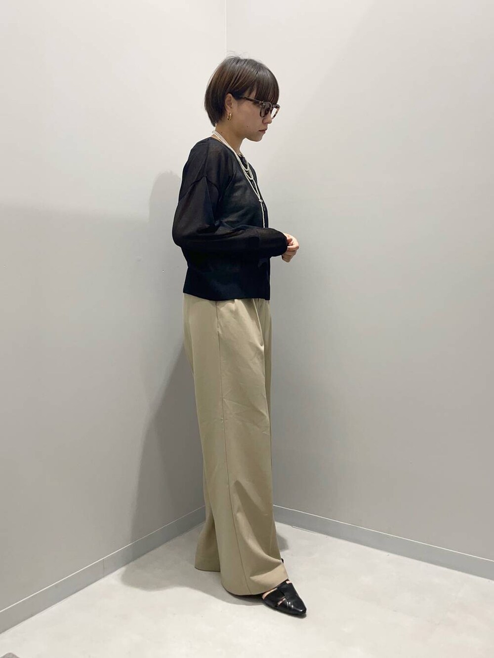 ベージュ系のその他パンツ、ブラック系のパンプス、ホワイト系のネックレスを着用したレディースの春コーディネートの3枚目の写真