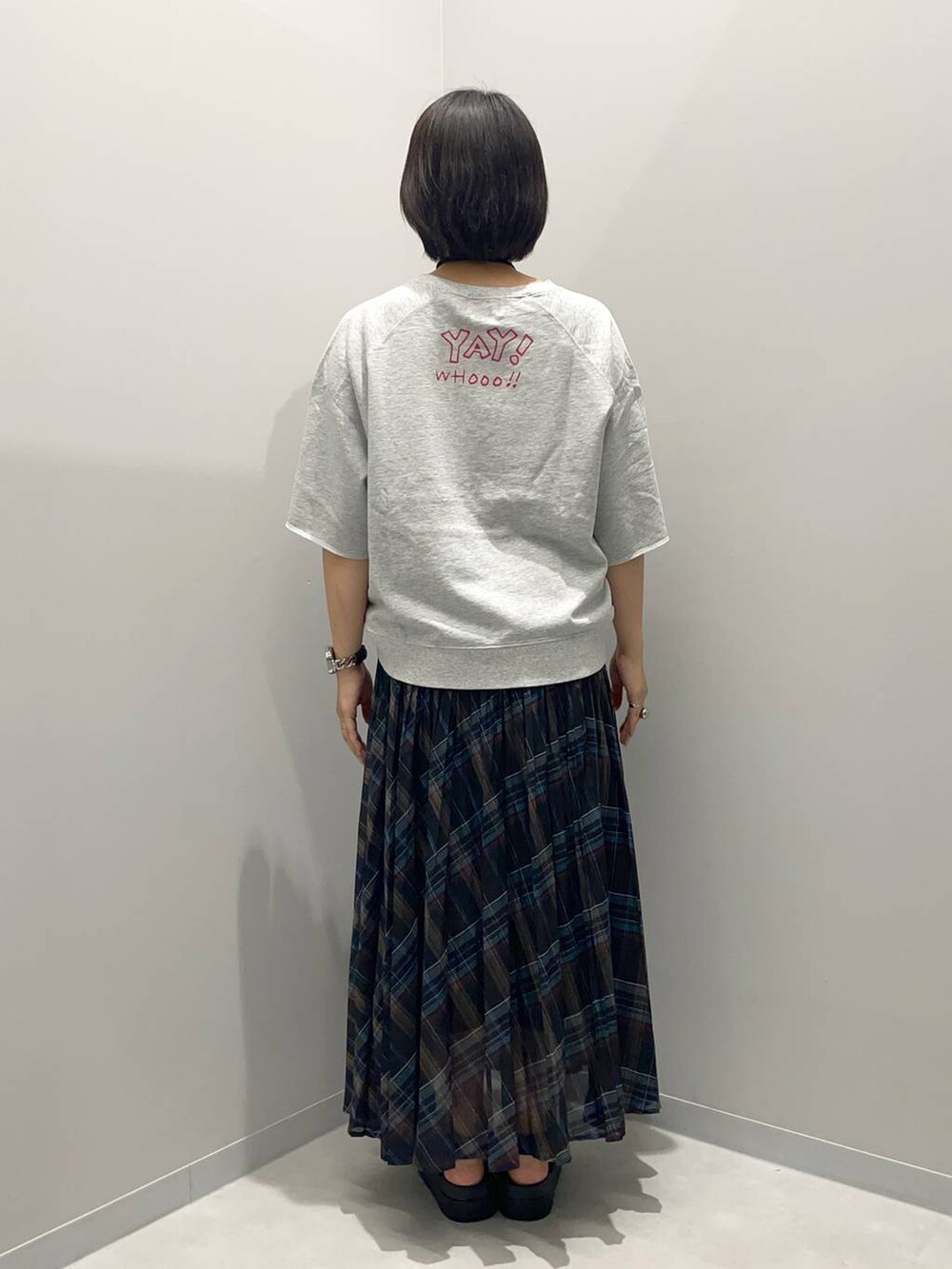 ブラック系のスカート、ゴールド系のチョーカーを着用したレディースの夏コーディネートの4枚目の写真