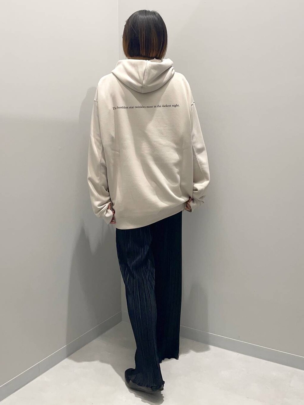 ベージュ系のパーカー、ブラック系のその他パンツを着用したレディースの秋コーディネートの3枚目の写真