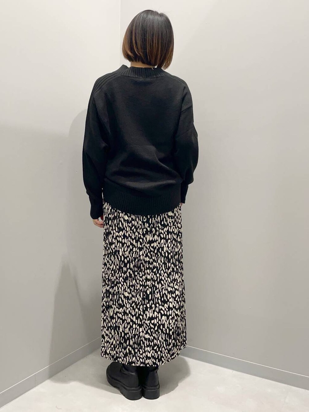 ブラック系のニット/セーター、グレー系のスカートを着用したレディースの秋コーディネートの4枚目の写真