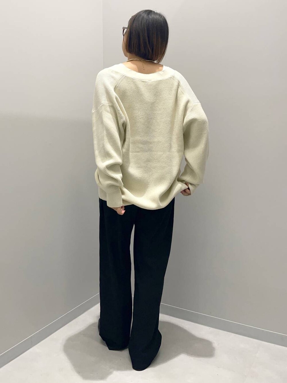 ブラック系のその他パンツ、ホワイト系のニット/セーター、イエロー系のバレッタ/ヘアクリップを着用したレディースの秋コーディネートの4枚目の写真
